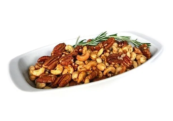 A white plate topped with nuts and rosemary.